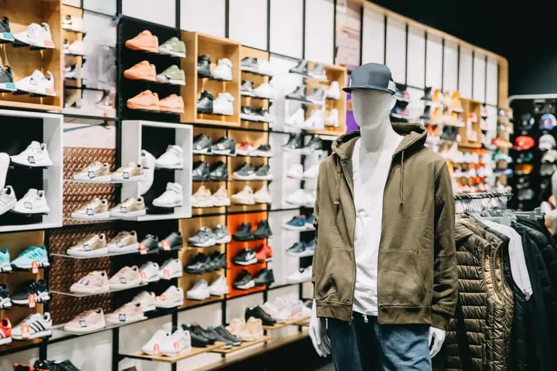 Shoppers browsing a footwear and apparel retail floor with a mannequin