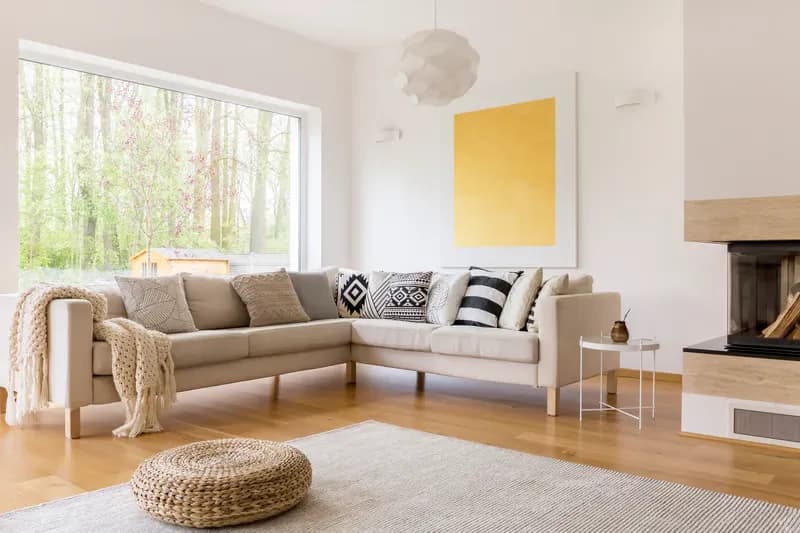 Bright living room with a sofa, cushions and a yellow artwork