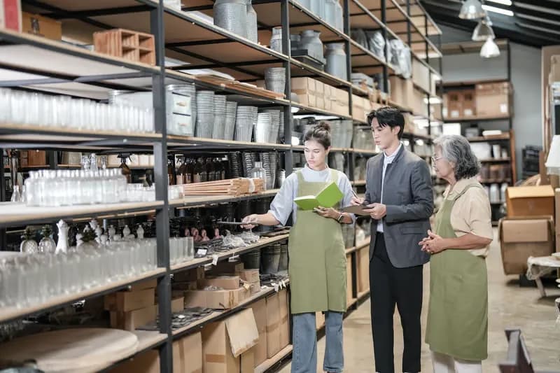 Colleagues reviewing stock between industrial storage shelves