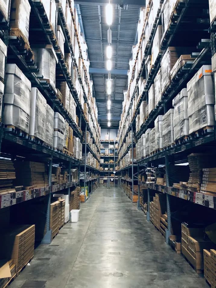 Long warehouse aisle lined with tall shelving full of stock