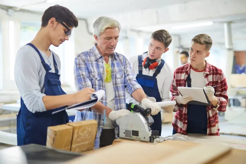 Team of workers reviewing a lot at a workshop bench